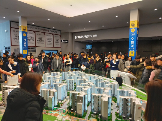 현대건설과 대우건설 컨소시엄이 지난 13일 문을 연 힐스테이트 수원 푸르지오 견본주택 방문객들이 분양관계자의 설명을 들으며 모형도를 둘러보고 있다.<박상길 기자>